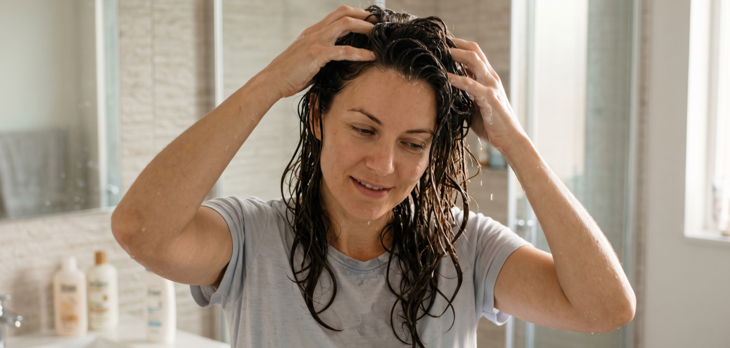 Woman massaging hair after applying hair serum