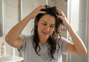 Woman massaging hair after applying hair serum
