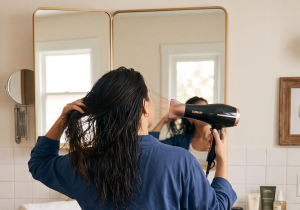 Person drying wet hair with a hairdryer